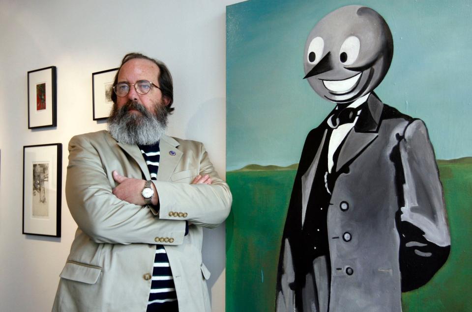 The late Scott Hatt poses in The Spurious Fugitive gallery in downtown South Bend that he owned from 2005 to 2008. He stands next to an oil painting titled "President Elect" by Heath Yenna.