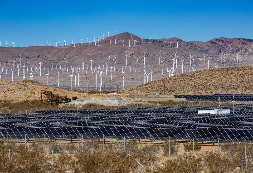 A large array of solar panels and wind propellers in Kern County.