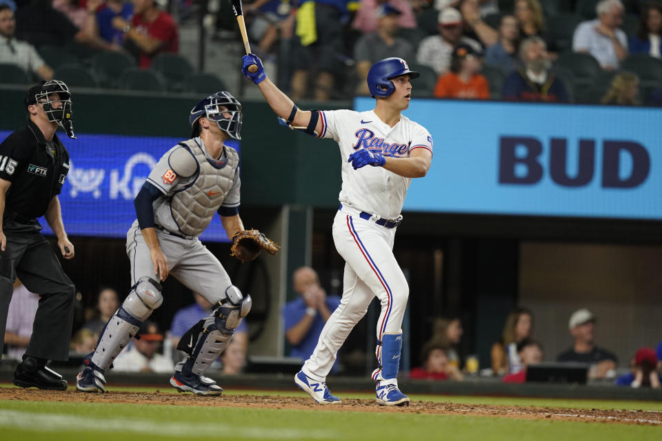 Texas Rangers' Nathaniel Lowe watches his his two-run home run next to Houston Astros catcher Jason Castro and umpire Junior Valentine during the fourth inning of a baseball game in Arlington, Texas, Tuesday, June 14, 2022. (AP Photo/LM Otero)