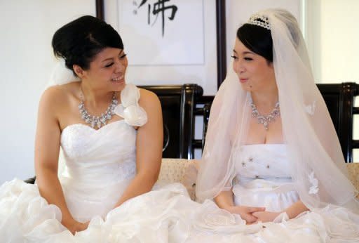 Taiwanese women Fish Huang (left) and her partner You Ya-ting smile during their same-sex Buddhist wedding ceremony in Taoyuan. The two women tied the knot in Taiwan's first same-sex Buddhist wedding, a move rights groups hope will help make the island the first society in Asia to legalise gay marriage