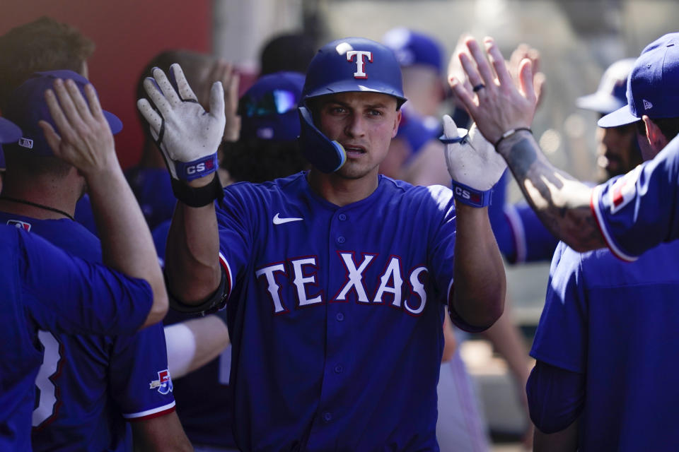 Texas Rangers' Corey Seager, right, celebrates in the dugout after hitting a home run during the fifth inning of a baseball game against the Los Angeles Angels in Anaheim, Calif., Sunday, Oct. 2, 2022. Marcus Seimen also scored. (AP Photo/Ashley Landis)