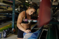 Canoe sprint world champion Nevin Harrison, 19, of Seattle, cleans her boat before she trains near Lake Lanier Olympic Park on Thursday, July 1, 2021, in Gainesville, Ga. Harrison won the world championship in the women's sprint canoe 200 meters as a 17-year-old in 2019. Now she'll try to duplicate that at the Olympics in Tokyo where the race will be a new event in a bid for gender equity. (AP Photo/Brynn Anderson)