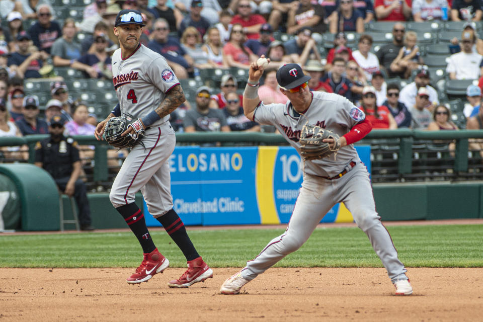 Minnesota Twins' Jose Miranda, right, throws to second base to force out Cleveland Guardians' Tyler Freeman as Twins' Carlos Correa (4) looks on during the fifth inning of a baseball game in Cleveland, Sunday, Sept. 18, 2022. (AP Photo/Phil Long)