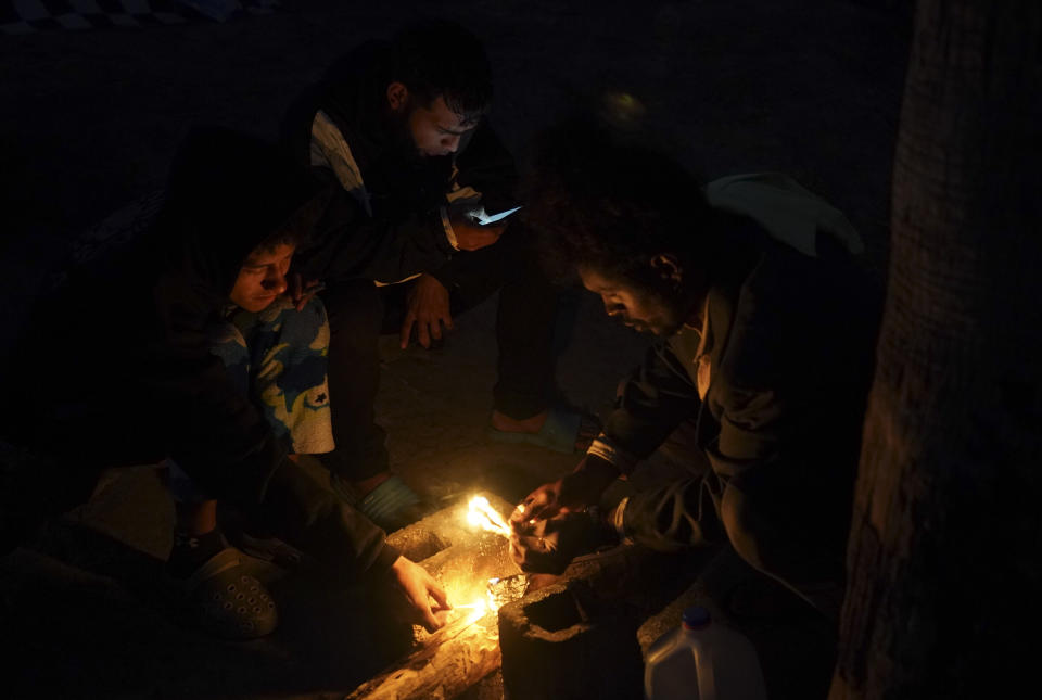 Venezuelan migrants build a campfire to keep warm at a makeshift camp along the Rio Grande river bank in Matamoros, Mexico, Thursday, Dec. 22, 2022. Migrants are waiting on a pending U.S. Supreme Court decision on asylum restrictions. (AP Photo/Fernando Llano)