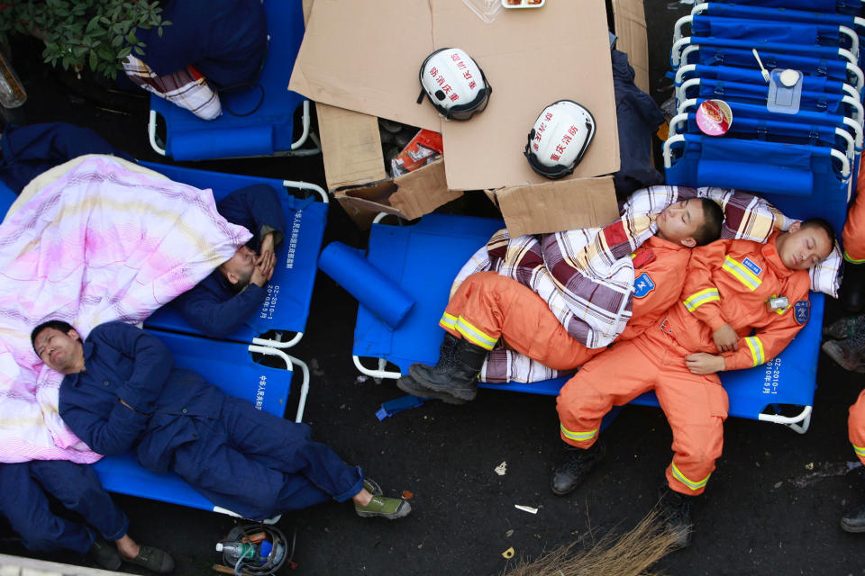 Rescuers rest near a site of explosion at coal mine in Chongqing