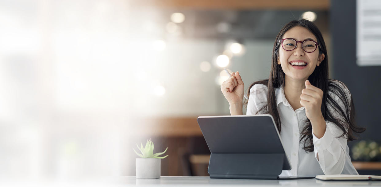 Businesswoman sitting in office with digital tablet, illustrating a story on negotiating salary.