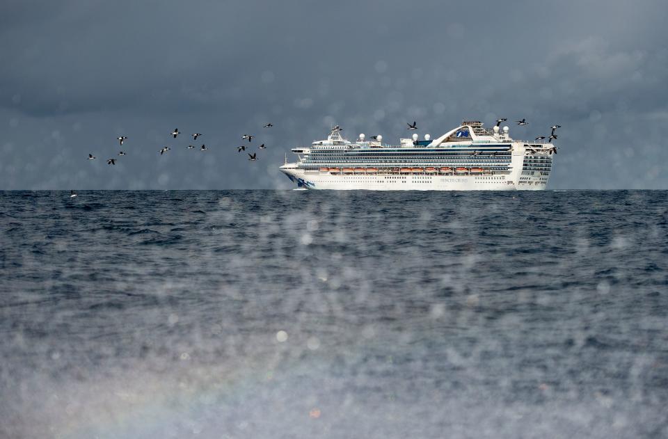 People look out from aboard the Grand Princess cruise ship, operated by Princess Cruises, as it maintains a holding pattern about 25 miles off the coast of San Francisco, California on March 8, 2020. (Photo by Josh Edelson / AFP)