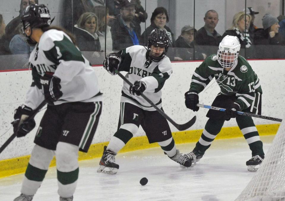 Duxbury's Sami Norton, center, passes to teammate McKenna Colella, left, as Canton's Tess Khoury, right, moves in during the Elite Eight state MIAA Division 2 girls hockey championship at The Bog in Kingston, Saturday, March 12, 2022.