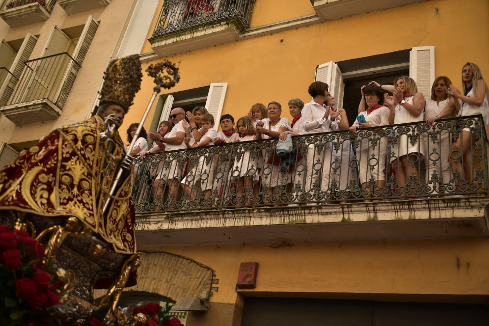 <p>People dressed in a red and white stand on a balcony to watch the San Fermin religious figure go by during the procession at the San Fermin Festival, in Pamplona, northern Spain, July 7, 2018. (Photo: Alvaro Barrientos/AP) </p>