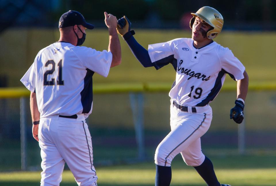 New Prairie’s Grady Kepplin celebrates a home run with his coach Mark Schellinger during the Marian vs. New Prairie sectional baseball game Wednesday, May 26, 2021 at Jim Reinebold Field in South Bend. 