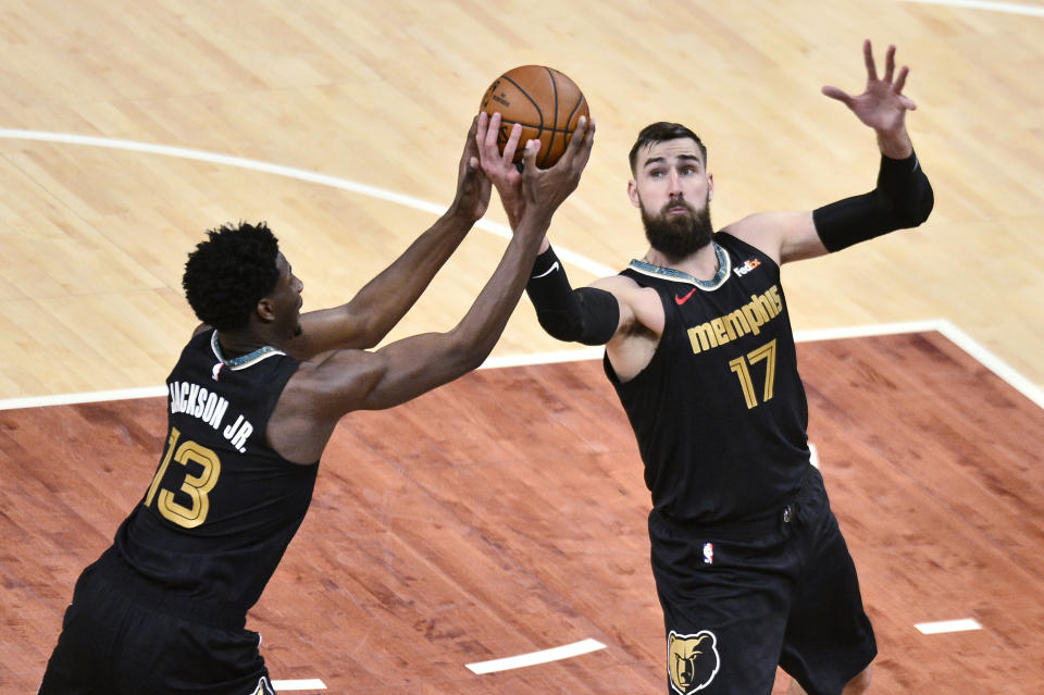 Memphis Grizzlies forward Jaren Jackson Jr. (13) and center Jonas Valanciunas (17) reach for the ball during the first half of an NBA basketball Western Conference play-in game against the San Antonio Spurs on Wednesday, May 19, 2021, in Memphis, Tenn. (AP Photo/Brandon Dill)