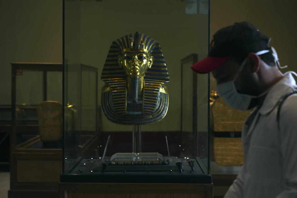 A worker disinfects around King Tut's famous mask in the Egyptian Museum in an effort to help prevent the spread of the coronavirus, in Tahrir Square, Cairo, Egypt, Monday, March 23, 2020. (AP Photo/Hamada Elrasam)