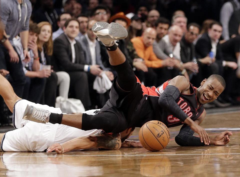 Toronto Raptors' Terrence Ross, right, and Brooklyn Nets' Deron Williams tumble to the court during the first half of Game 3 of an NBA basketball first-round playoff series Friday, April 25, 2014, in New York. (AP Photo/Frank Franklin II)