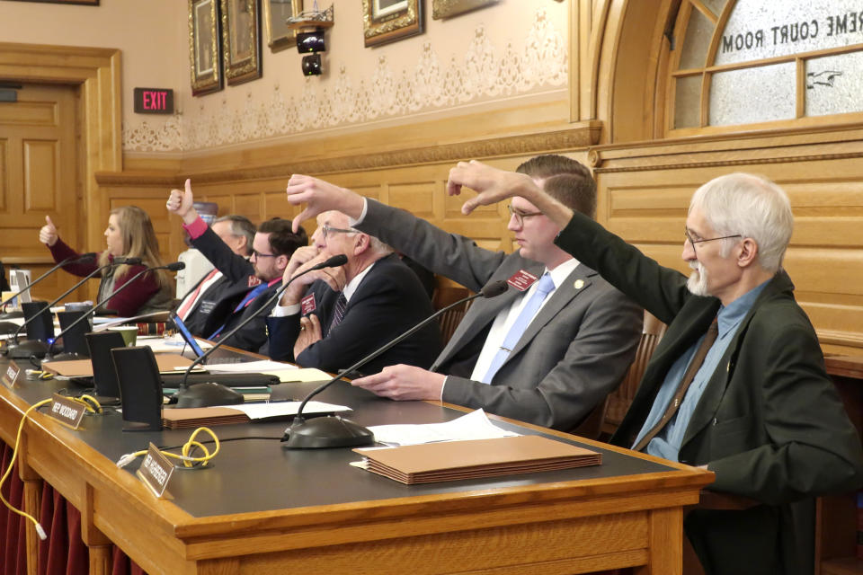 Members of a Kansas House committee indicate whether they want to be recorded as voting yes or no on a proposed amendment to the state constitution on abortion with thumbs-up and thumbs-down signs, Wednesday, Jan. 22, 2020, at the Statehouse in Topeka, Kan. The measure cleared committee on a 15-6 show of hands and would reverse a Kansas Supreme Court decision declaring access to abortion a "fundamental" right under the state constitution. (AP Photo/John Hanna)