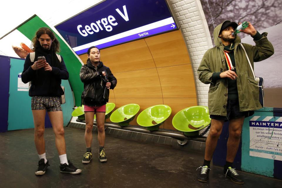 Passengers without their pants wait for a train during the "No Pants Subway Ride" event at a subway station in Paris