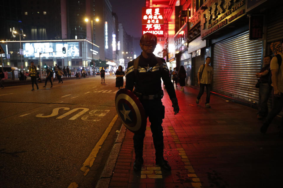 A protester dressed as the super hero character Captain America walks along the street during a rally in Hong Kong on Sunday, Oct. 27, 2019. Hong Kong police fired tear gas Sunday to disperse a rally called over concerns about police conduct in monthslong pro-democracy demonstrations, with protesters cursing the officers and calling them "gangster cops." (AP Photo/Kin Cheung)