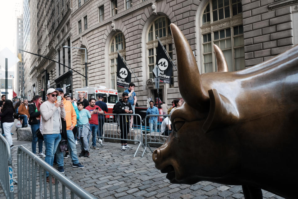 NEW YORK, NEW YORK - MAY 05: People pose by the Wall Street Bull near the New York Stock Exchange (NYSE) on May 05, 2022 in New York City. The Dow Jones Industrial Average fell over 1000 points as inflation fears continue to worry investors. (Photo by Spencer Platt/Getty Images)