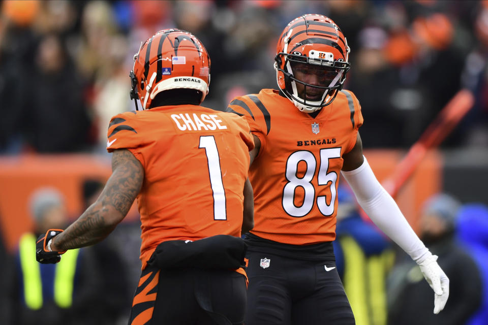 Cincinnati Bengals wide receiver Tee Higgins (85) high fives wide receiver Ja'Marr Chase (1) during an NFL football game against the Kansas City Chiefs, Sunday, Jan. 2, 2022, in Cincinnati. (AP Photo/Emilee Chinn)