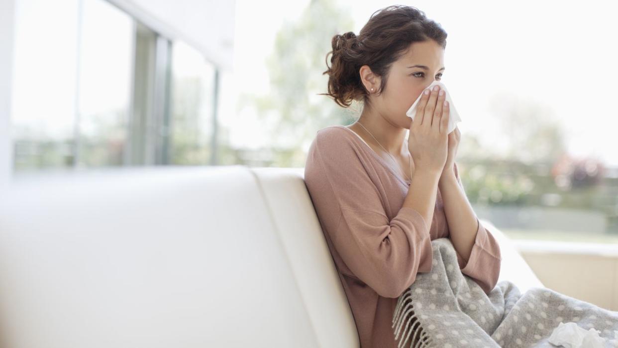 sick woman blowing her nose