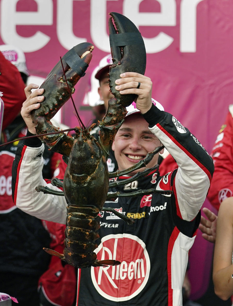 Christopher Bell holds up a giant lobster while celebrating after winning a NASCAR Cup Series auto race at the New Hampshire Motor Speedway, Sunday, July 17, 2022, in Loudon, N.H. (AP Photo/Charles Krupa)