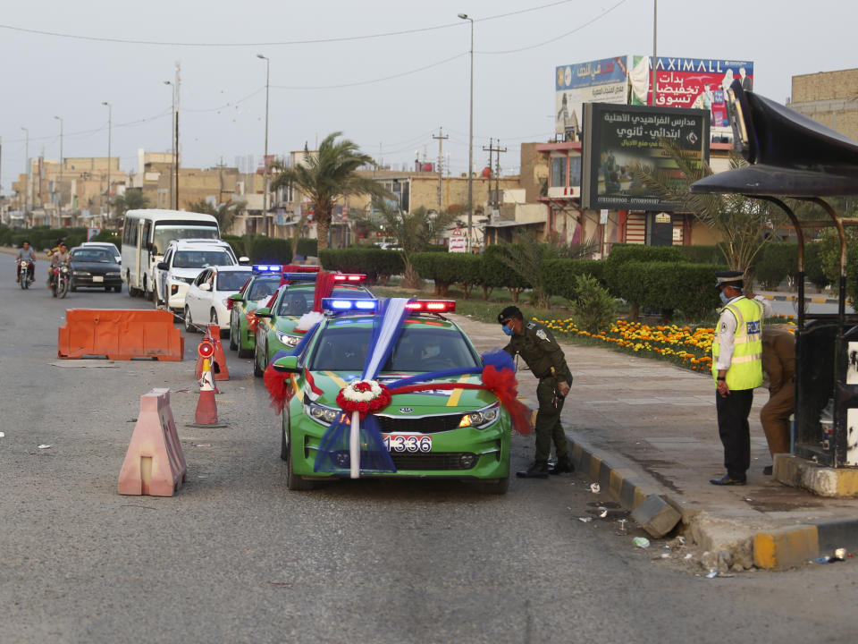 In this Thursday, April 9, 2020 photo, police convoy transports Ahmed Khaled al-Kaabi and his bride Ruqaya Rahim during their wedding in Najaf, Iraq, hardest hit town by coronavirus in the country with government banned large public gatherings. Unwilling to postpone the wedding, al-Kaabi asked the local security forces to help him wed his beloved. The police responded by providing the groom vehicles blasting music to bring his bride to the family home for a small celebration of just six people. (AP Photo/Anmar Khalil)