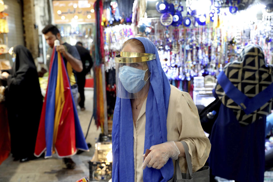 A woman wearing a protective face mask and gloves to help prevent the spread of the coronavirus walks through the Tajrish traditional bazaar in northern Tehran, Iran, Thursday, Oct. 15, 2020. Eight months after the pandemic first stormed Iran, pummeling its already weakened economy and sickening officials at the highest levels of its government, authorities appear just as helpless to prevent its spread. (AP Photo/Ebrahim Noroozi)