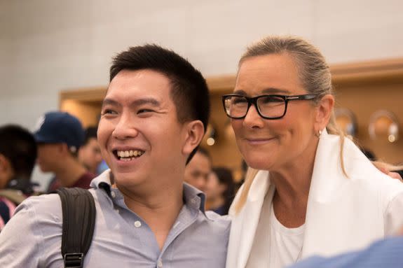 A customer poses for a photo with Angela Ahrendts, senior VP of retail at Apple