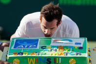 Andy Murray pretends to take a bite of a cake presented to him after his 500th ATP win after defeating Kevin Anderson (not pictured) on day nine of the Miami Open at Crandon Park Tennis Center. Murray won 6-4, 3-6, 6-3. Mandatory Credit: Geoff Burke-USA TODAY Sports