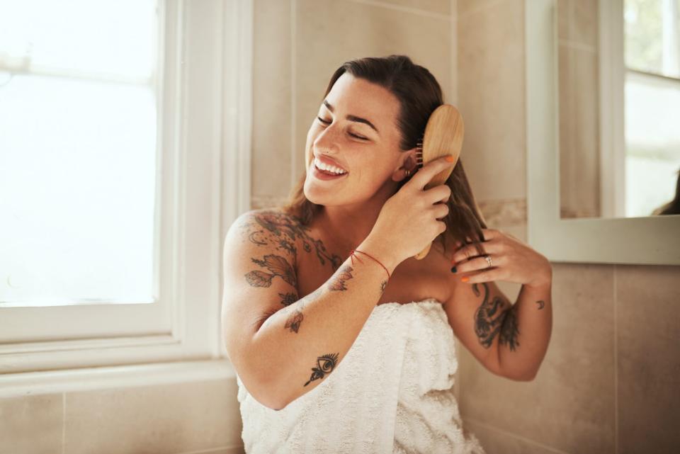 woman brushing hair in bathroom