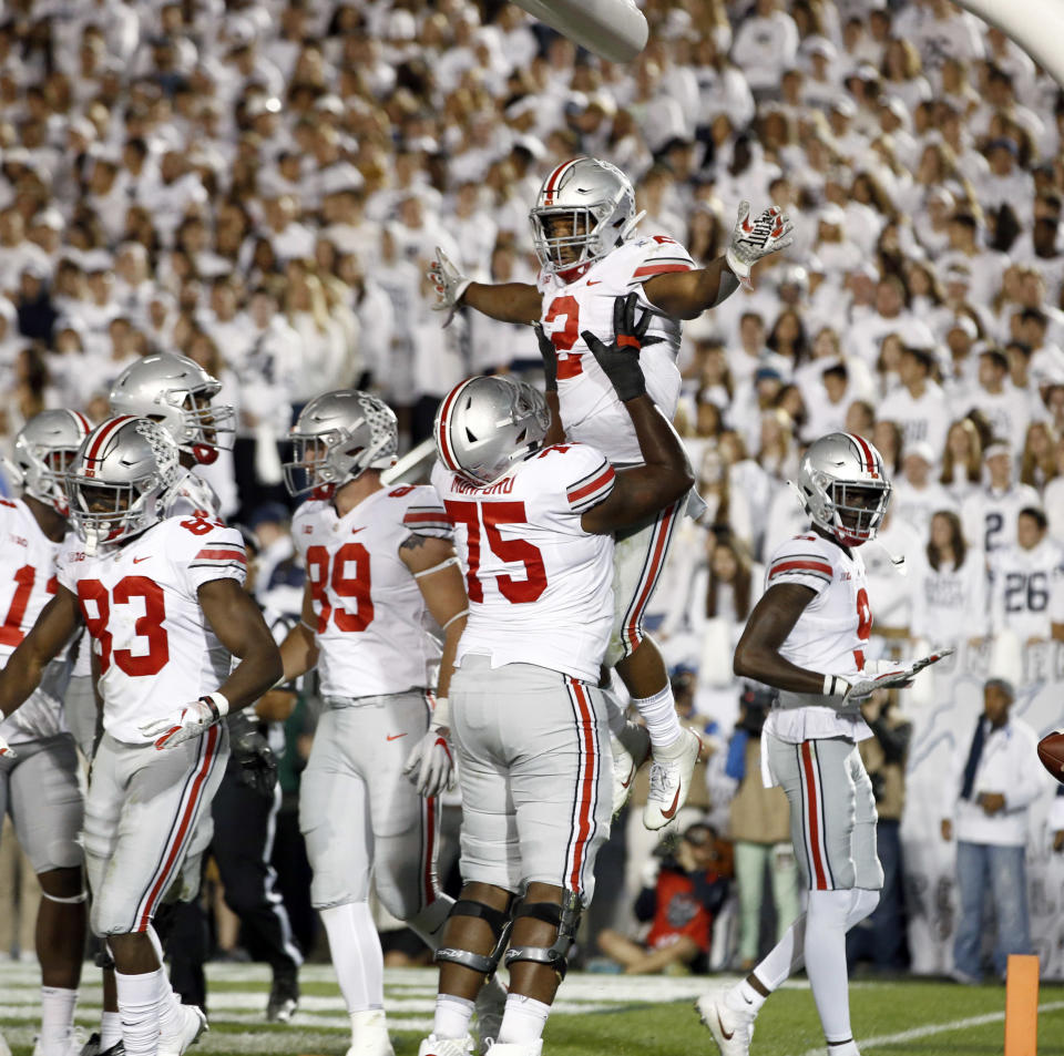 Ohio State's J.K. Dobbins (2) is lifted up by teammate Thayer Munford (75) after scoring against Penn State during the second half of an NCAA college football game in State College, Pa., Saturday, Sept. 29, 2018. Ohio State won 27-26. (AP Photo/Chris Knight)