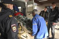 Medical staff carry an injured person into an ambulance at the emergency department of the First Republican Clinical hospital to evacuate to Moscow, in Izhevsk, Russia, Tuesday, Sept. 27, 2022. The plane of the Ministry of Emergency Situations will deliver victims of the shooting at school No. 88 in Izhevsk to Moscow hospitals. This was stated by the Presidential Commissioner for Children's Rights Maria Lvova-Belova. According to officials, 11 children were among those killed in the Monday morning shooting in School No. 88 in Izhevsk, a city 960 kilometers (600 miles) east of Moscow.(AP Photo/Dmitry Serebryakov)