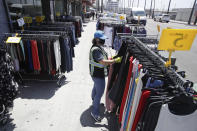 A woman shops for clothes Wednesday, May 27, 2020, in Los Angeles. California moved to further relax its coronavirus restrictions and help the battered economy. Retail stores, including those at shopping malls, can open at 50% capacity. (AP Photo/Marcio Jose Sanchez)