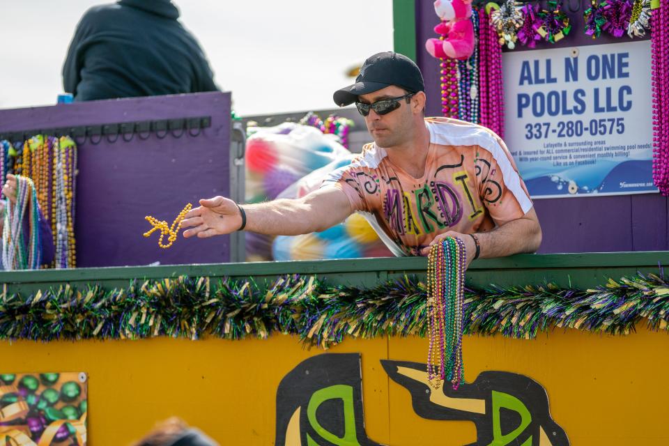 Float-riders throw beads to spectators as the Independent Parade rolls through downtown Lafayette on Mardi Gras Day, March 5, 2019.