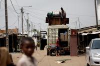 People gather their belongings as they prepare to leave their houses at Adjoufou in the area around Felix Houphouet Boigny airport in Abidjan