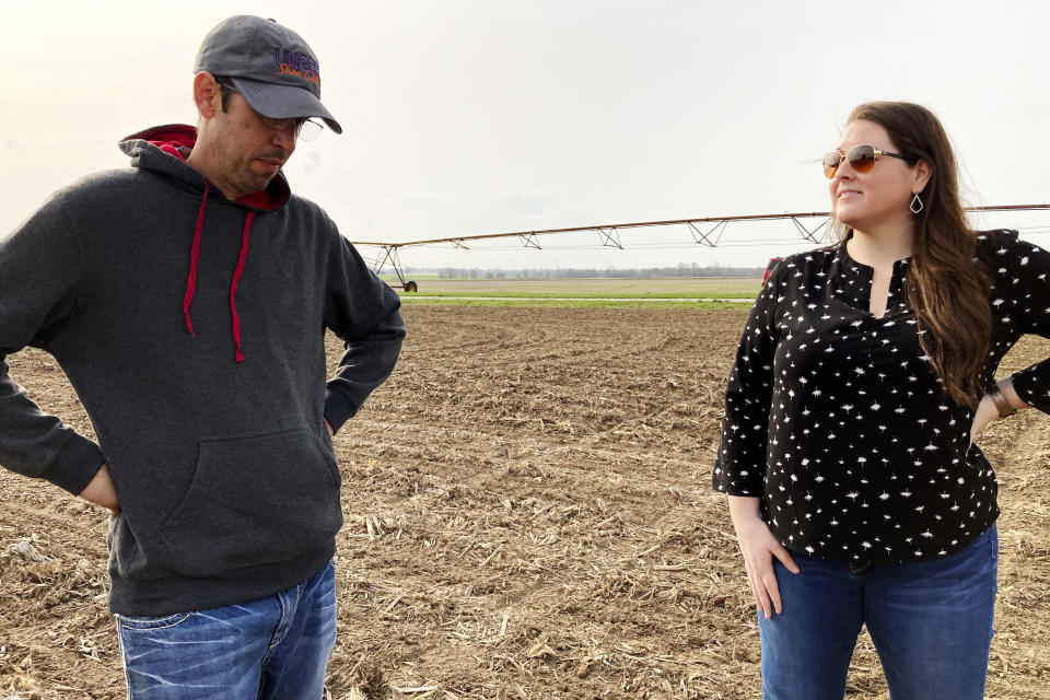 Farmer Lance Unger, left, and crop production specialist Kacee Bohle of Indigo Agriculture discuss techniques such as strip tillage and planting cover crops to improve soil health and yields while storing more carbon in the ground, in Carlisle, Indiana on April 6, 2021. The Biden administration is encouraging government and private initiatives that encourage such practices on farms as one strategy for fighting climate change while boosting the rural economy. (AP Photo/John Flesher)