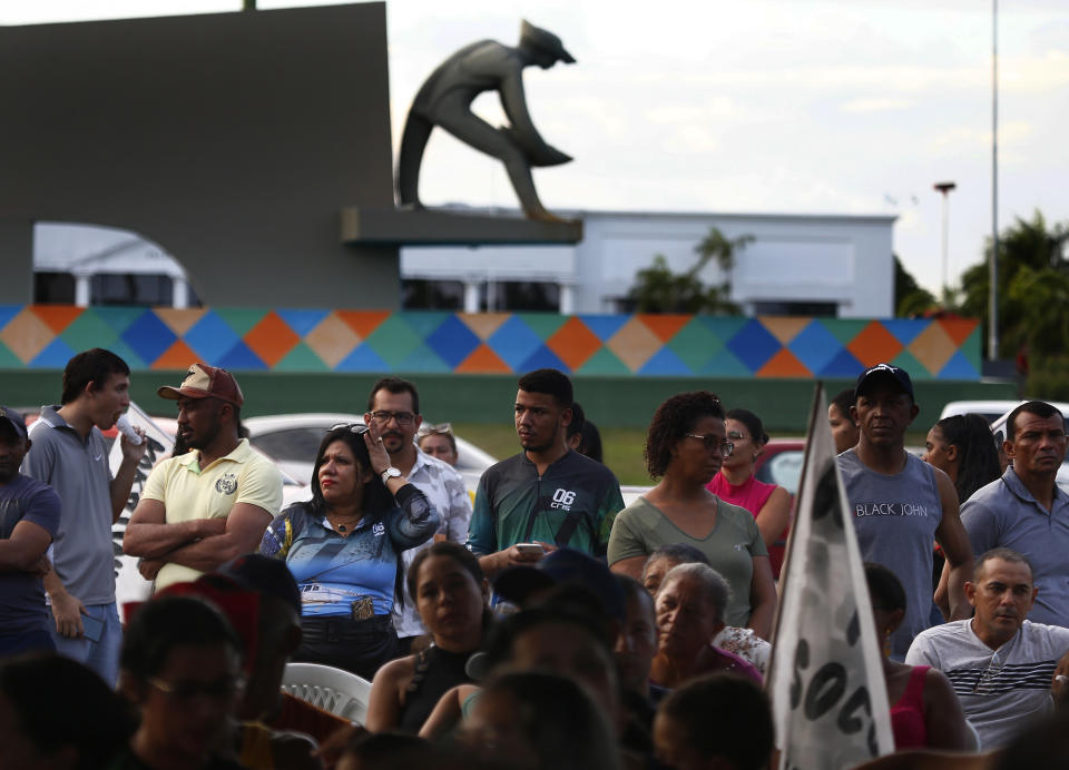 Miners and their relatives stand in front a statue of a gold miner, during a demonstration in defense of mining activities in Boa Vista, Roraima state, Brazil, Thursday, Feb. 9, 2023. (AP Photo/Edmar Barros)