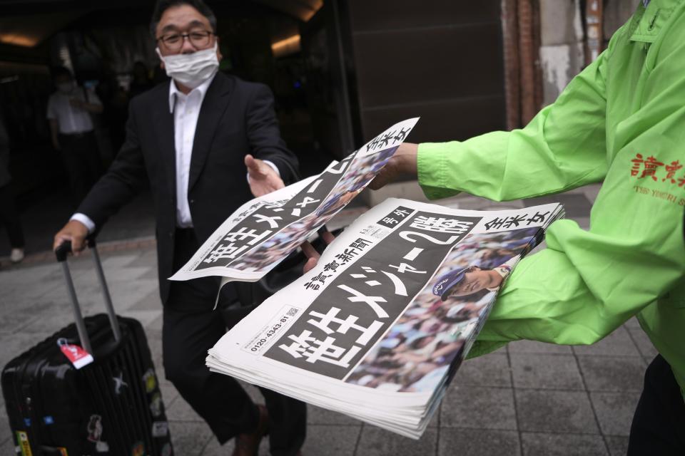 A staff distributes an extra edition of the Yomiuri Shimbun newspaper reporting on Japanese golfer Yuka Saso winning the U.S. Women's Open golf tournament Monday, June 3, 2024, in Tokyo. The Japanese title reads as "Saso won second major." (AP Photo/Eugene Hoshiko)