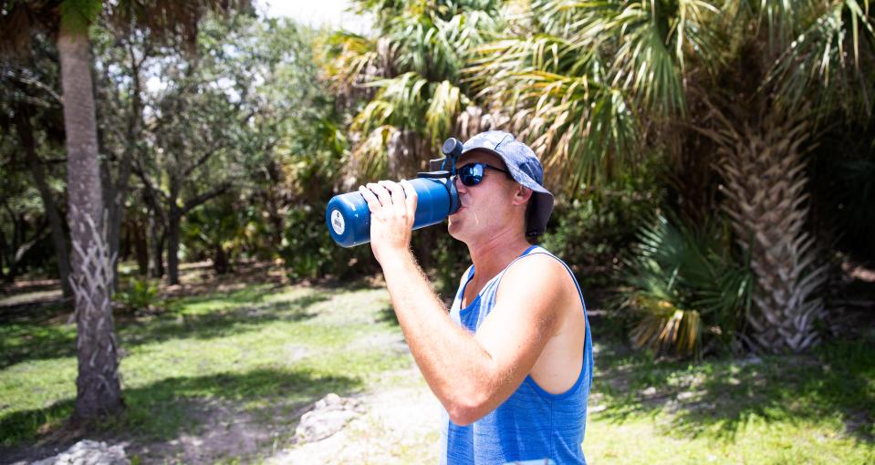 Jason Smith takes a swig of water while playing disc golf at Estero Community Park. Temps at the park were in the mid to upper 90Õs.