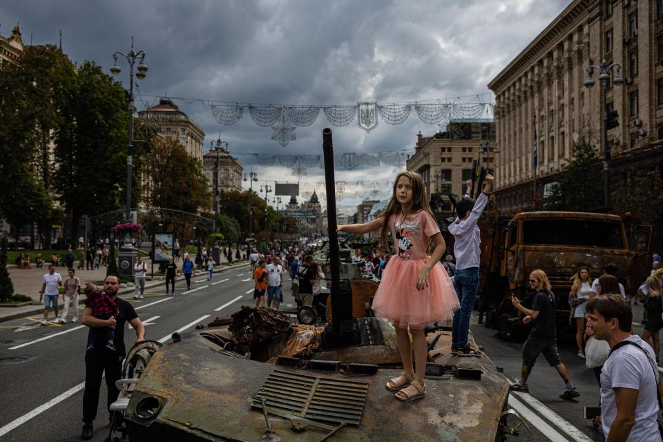 A girl stands Saturday on top of destroyed Russian military equipment at Khreshchatyk boulevard in Kyiv, which has been turned into an open-air military museum ahead of Ukraine's Independence Day on Aug. 24.
