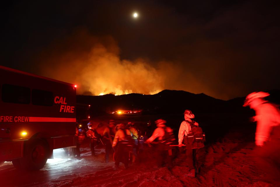 Firefighters from California Conservation Corps return to their vehicle while working the Fairview Fire on Monday near Hemet, Calif. The 2,000-acre brush fire left two dead and destroyed several homes amid an intense heat wave in Southern California.