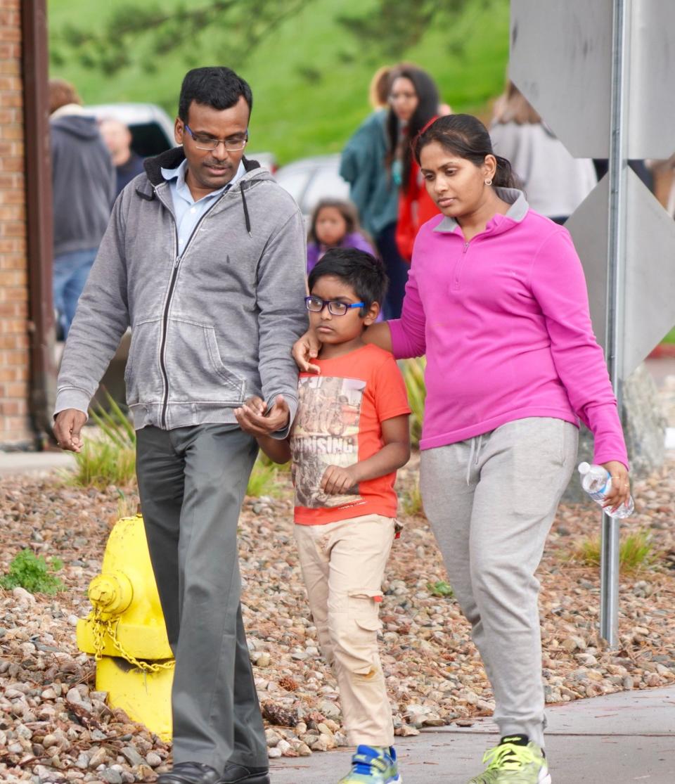 Bharani Rayana, 39, and Madhuri Adari, 32, hold tight to their second-grade son Daksha Rayana 8, following reunification at the Highlands Ranch Recreation Center after a school shooting.