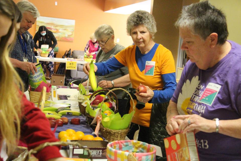 Terri Cooper, of Minburn Communications, works to add fresh fruit to baskets for the Perry Lutheran Homes' Project Deliver the LOVE initiative on Wednesday, May 4, 2022.