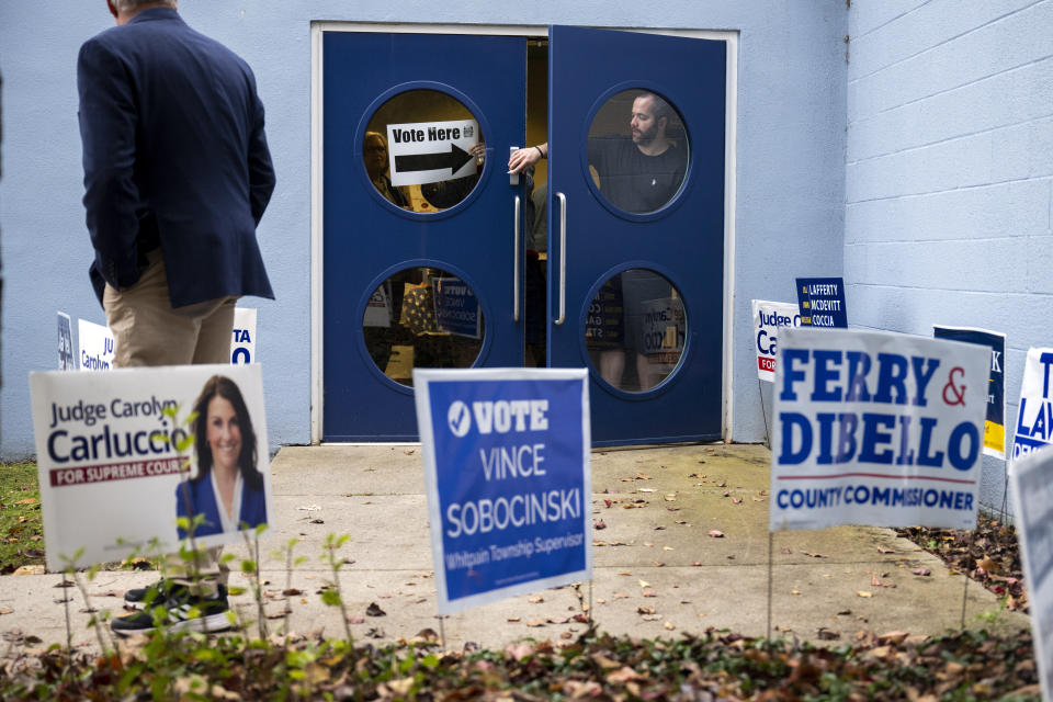 Officials adjust a sign on Election Day at the Wissahickon Valley Public Library in Blue Bell, Pa. on Tuesday, Nov. 7, 2023. (AP Photo/Joe Lamberti)