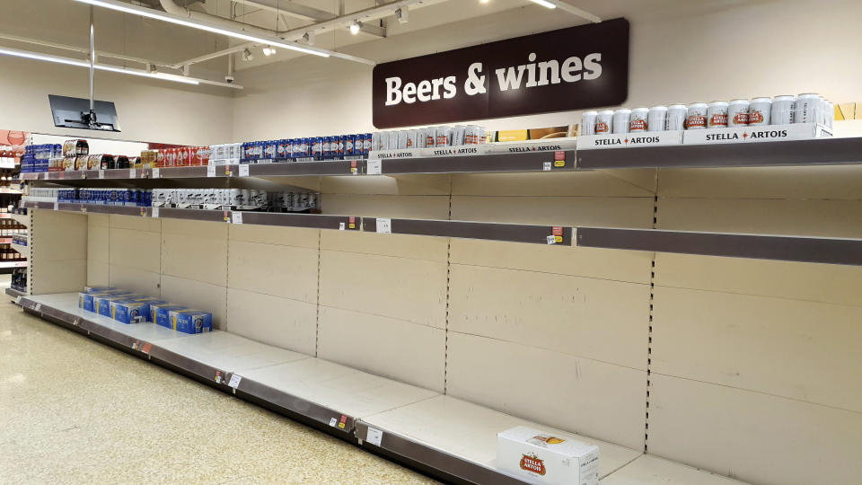 Nearly empty supermarket shelves in Ashford, south east England, Monday March 16, 2020. For most people, the new coronavirus causes only mild or moderate symptoms, such as fever and cough. For some, especially older adults and people with existing health problems, it can cause more severe illness, including pneumonia. (Gareth Fuller/PA via AP)