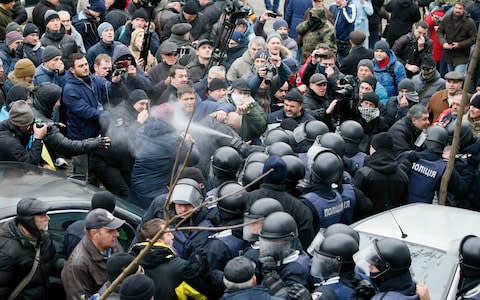 Police spray tear gas at protesters who tried to prevent a van from taking Mr Saakashvili away. - Credit: Gleb Garanich/Reuters