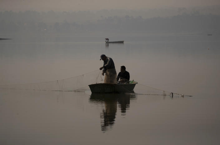 Fishermen fish in the waters of the Villa Victoria Dam, the main water supply for Mexico City residents, on the outskirts of Toluca, Mexico Thursday, April 22, 2021. Drought conditions now cover 85% of Mexico, and in areas around Mexico City and Michoacán, the problem has gotten so bad that lakes and reservoirs are drying up. (AP Photo/Fernando Llano)