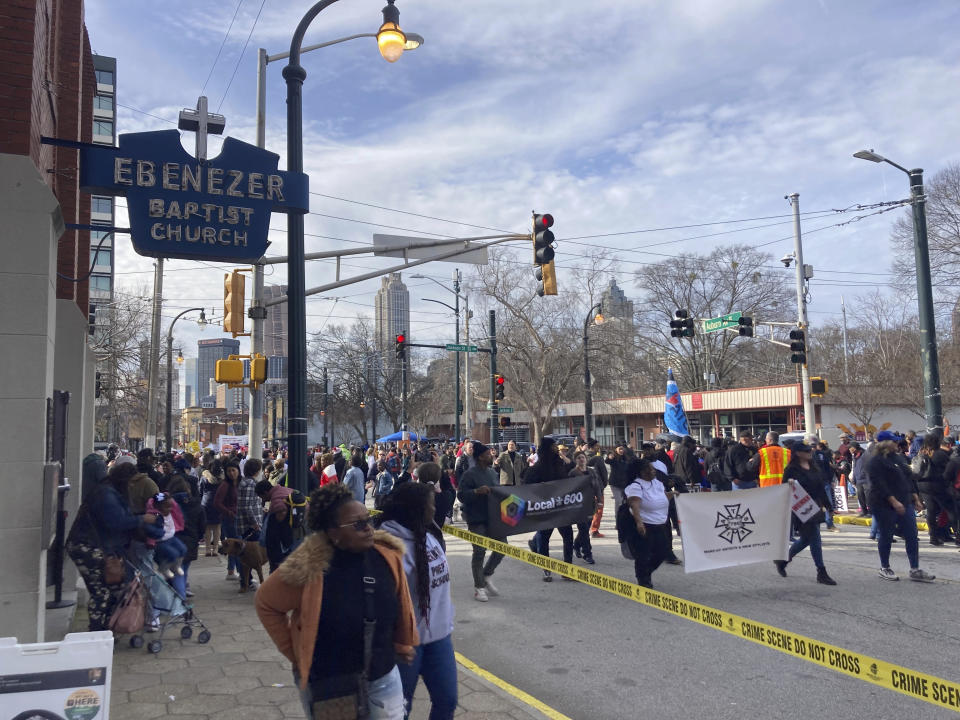 Union laborers, voting rights advocates and civil rights activists march down Auburn Avenue in Atlanta, Monday, Jan. 16, 2023, between the old Ebenezer Baptist Church where Martin Luther King Jr. once preached and the church's new campus. They marched as part of the 38th federal holiday observance honoring the slain civil rights leader. (AP Photo/Bill Barrow)