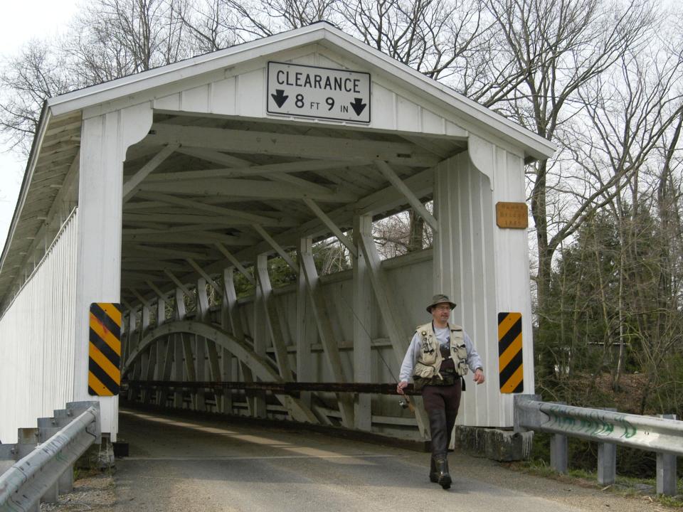 A bridge near Volant, Pennsylvania with a man walking past it