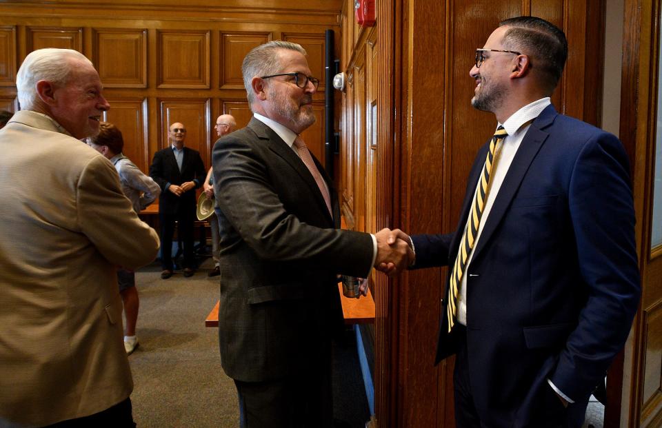 Former Worcester City Manager Michael O'Brien, left, shakes hands with current Acting City Manager Eric Batista before the unveiling ceremony for his portrait at city hall Friday.