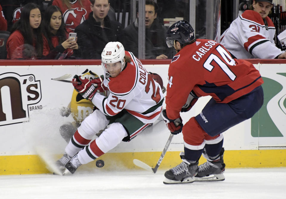 New Jersey Devils center Blake Coleman (20) and Washington Capitals defenseman John Carlson (74) vie for the puck during the second period of an NHL hockey game Friday, Dec. 20, 2019, in Newark, N.J. (AP Photo/Bill Kostroun)